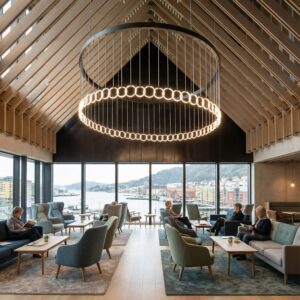 Massive black ring chandelier with suspended LED loops hanging in a timber-roofed cultural center in Bergen overlooking the harbor