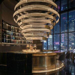 Massive tiered gold ring chandelier with fluted glass hanging over a circular bar in a Seoul Gangnam luxury lounge